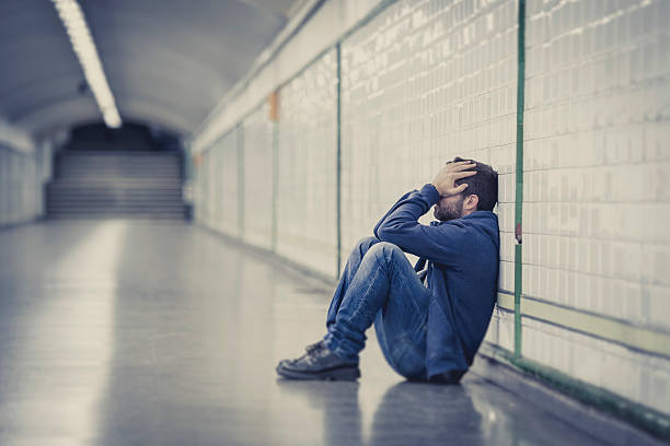 man-lost-in-depression-sitting-on-ground-street-subway-tunnel-picture-id515010131