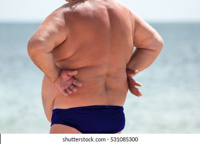 Back view of overweight man. Obese man outdoor. Great danger for health. Increased risk of heart attack.