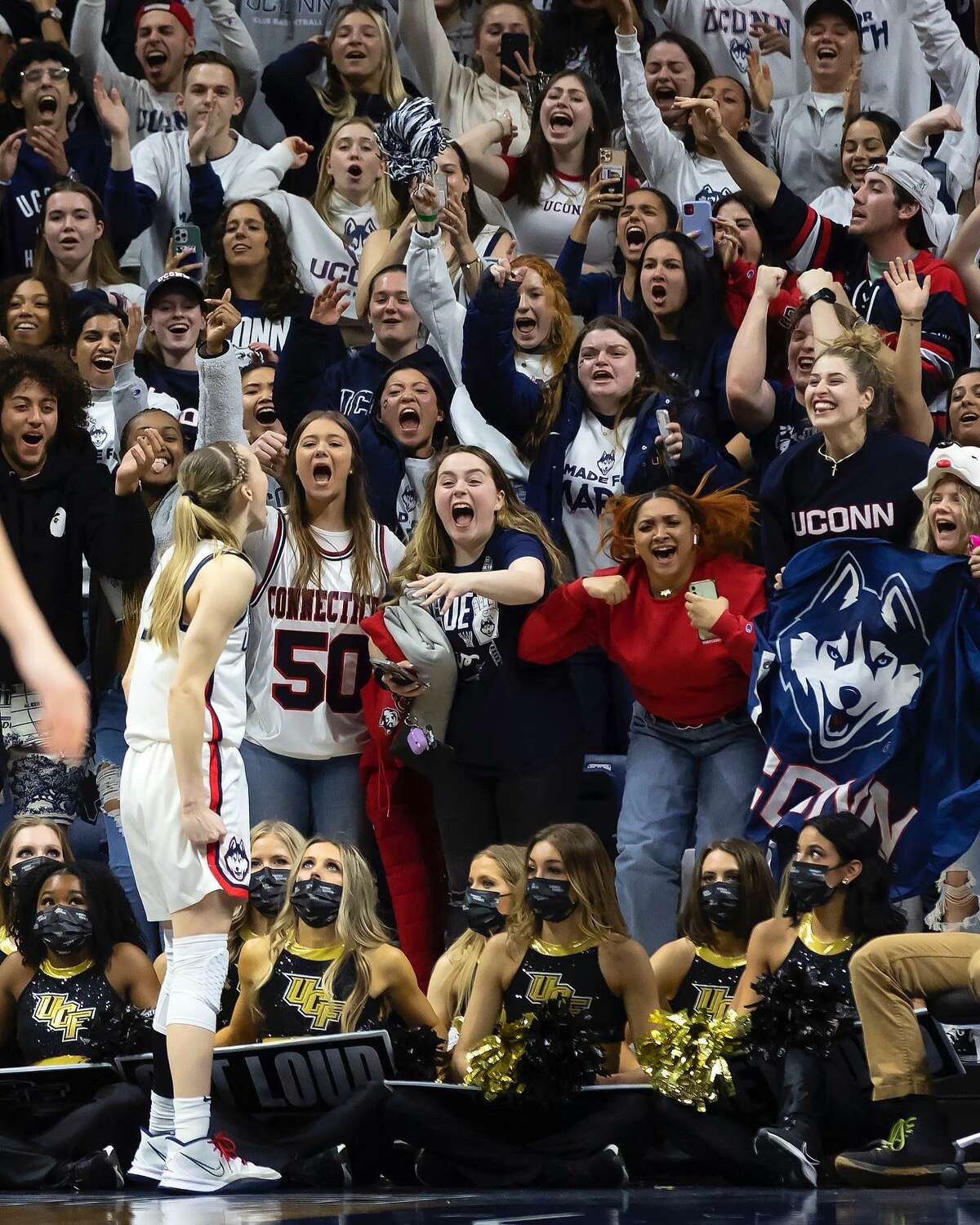 Taylor Coonan (center with dark jacket and white shirt) and Camryn Walsh (left of Coonan) were part of the student section reacting to Paige Bueckers during UConn’s win over UCF Monday, March 21, 2022. The UConn photo went viral on social media this week.